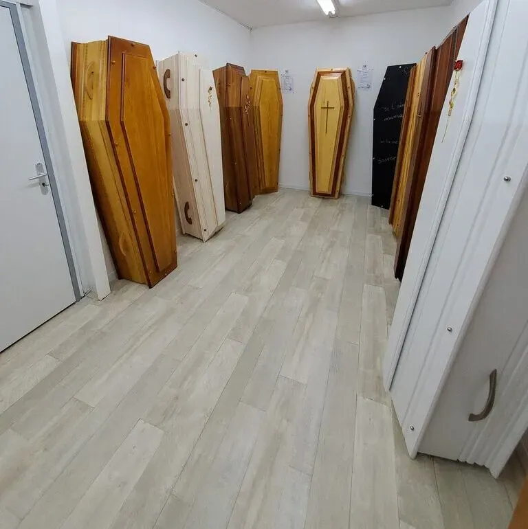 Salle d'exposition présentant divers modèles de cercueils en bois pour obsèques.