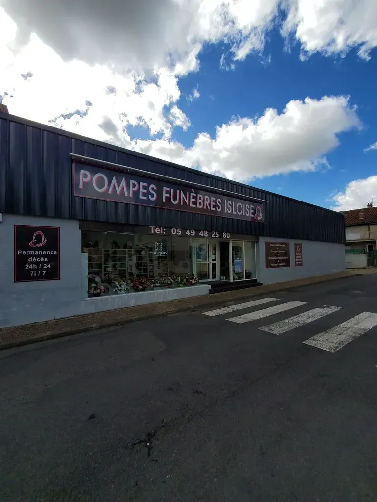 Façade extérieure de l'agence de pompes funèbres Isloise sous un ciel nuageux.