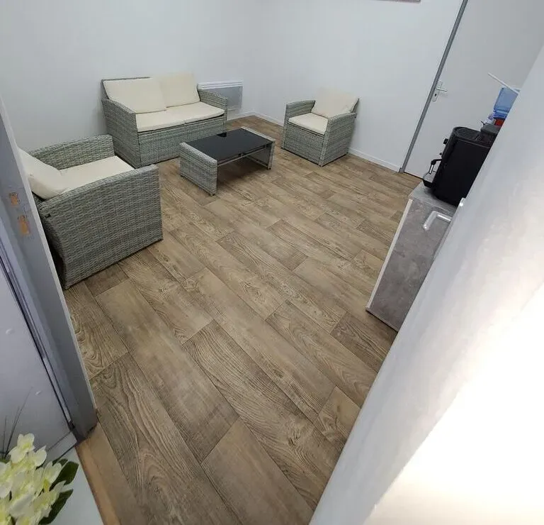 Espace d'accueil et de recueillement aménagé avec fauteuils et table basse.