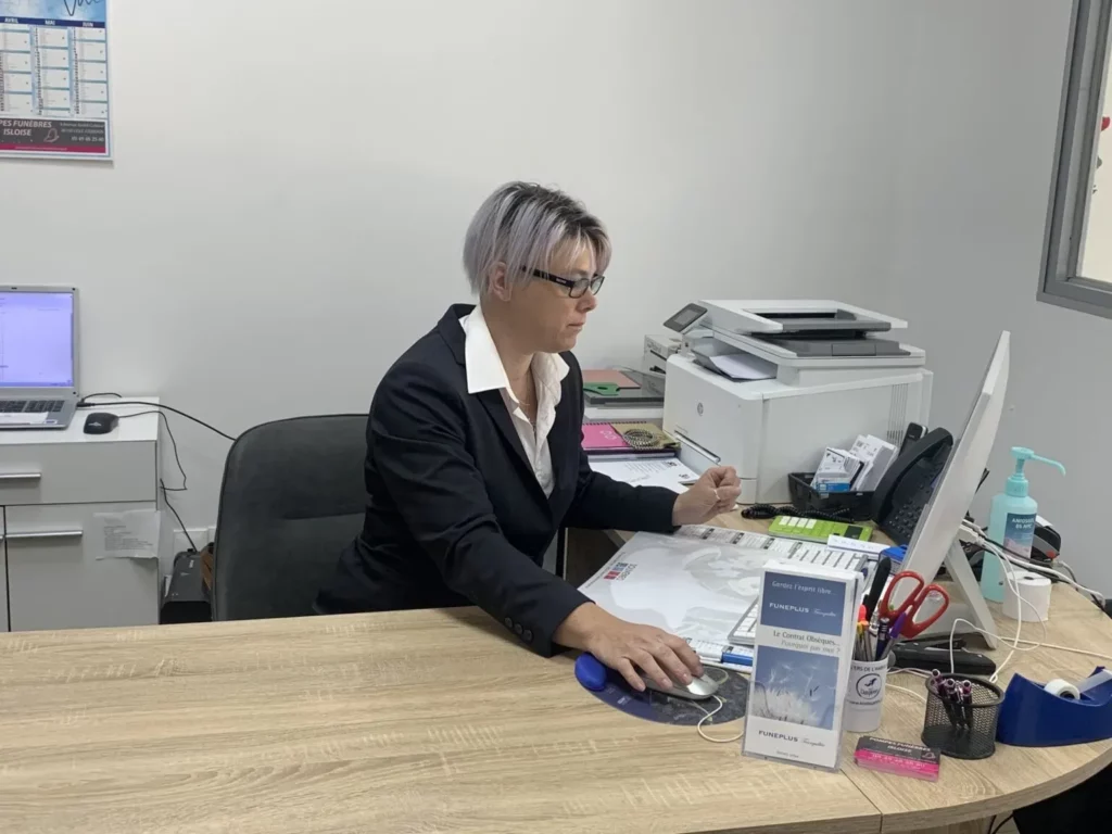 Conseillère funéraire travaillant sur son ordinateur à son bureau d'accueil.